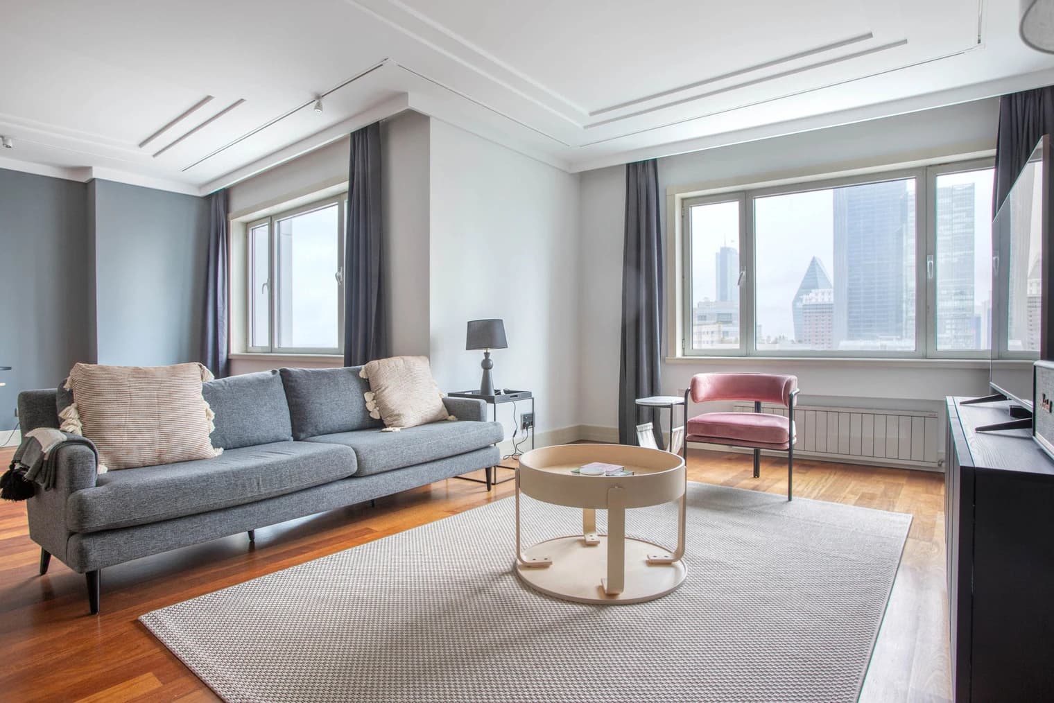 Furnished living room with two windows in the Metrocity apartment
